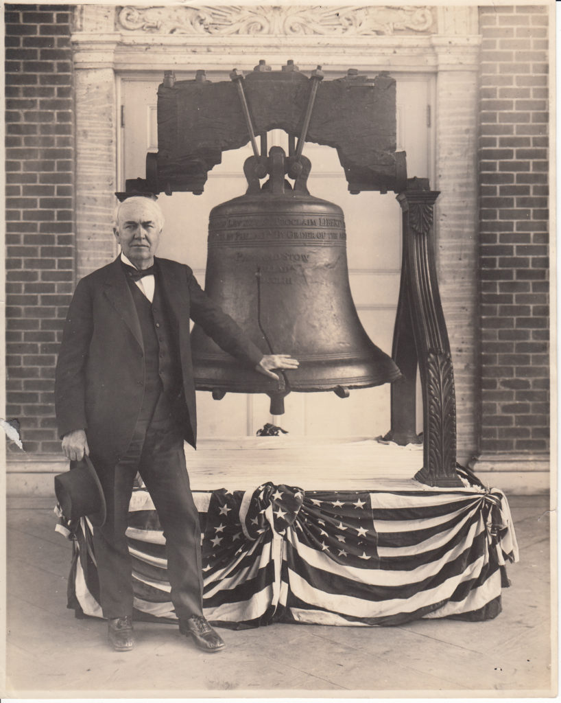 Thomas Edison standing next to the Liberty Bell on California trip, at the Panama-Pacific Exposition.