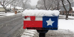 A mailbox painted in Texas flag covered with snow beside a Texas road on January 2021. Copy Space.